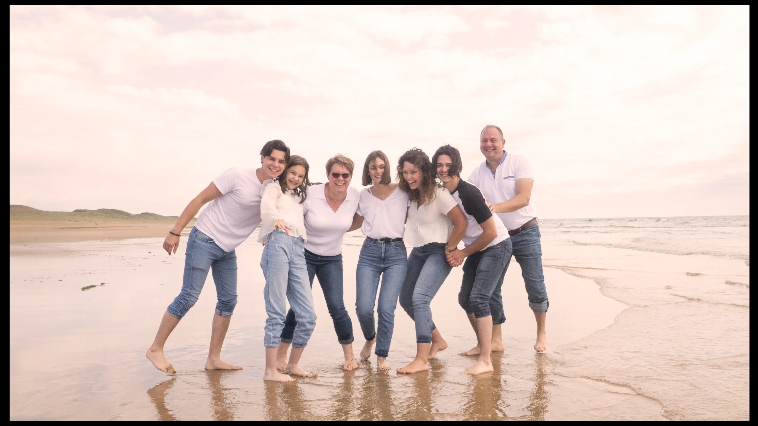 Famille avec enfants les pieds dans l'eau sur la plage de Brétignolles-sur-Mer